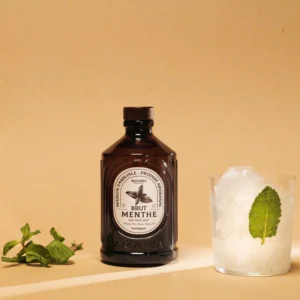 Sirop de menthe bio Bacanha bouteille ambrée 400ml avec verre glacé et feuille de menthe fraîche