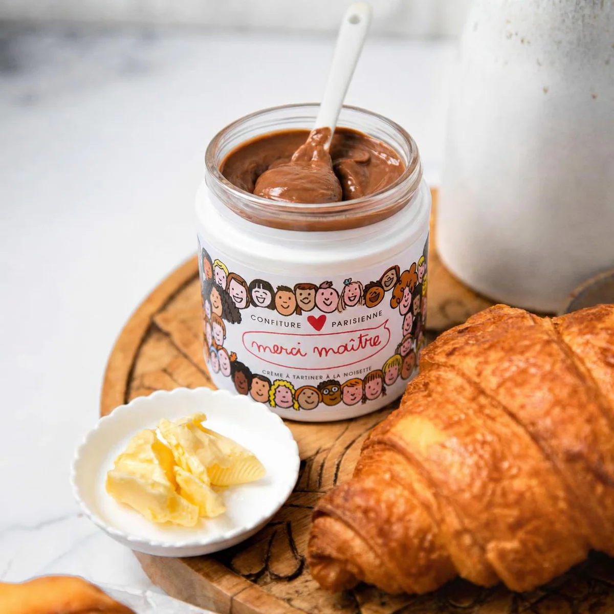 Pâte à tartiner Merci Maître à la noisette servie au petit-déjeuner avec croissant